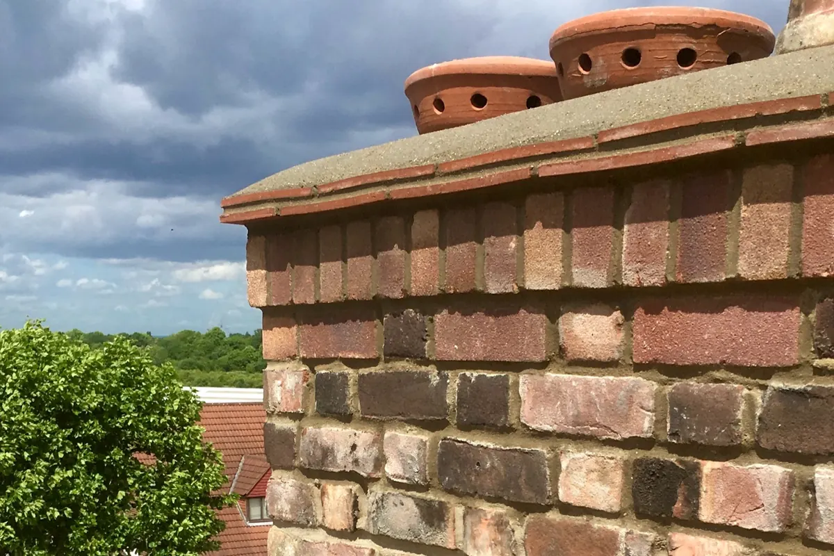 Completed chimney stack rebuild in Canterbury with renewed brickwork, coping and pots