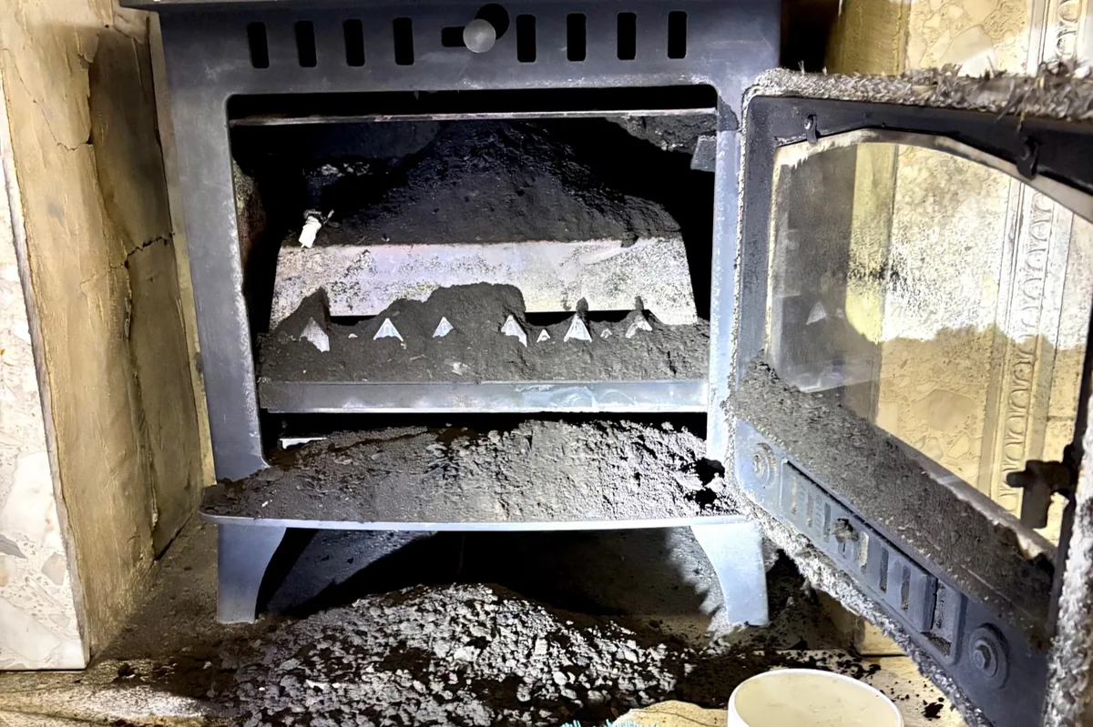 Severe soot and ash build-up inside wood burning stove during chimney sweep in Margate, Kent